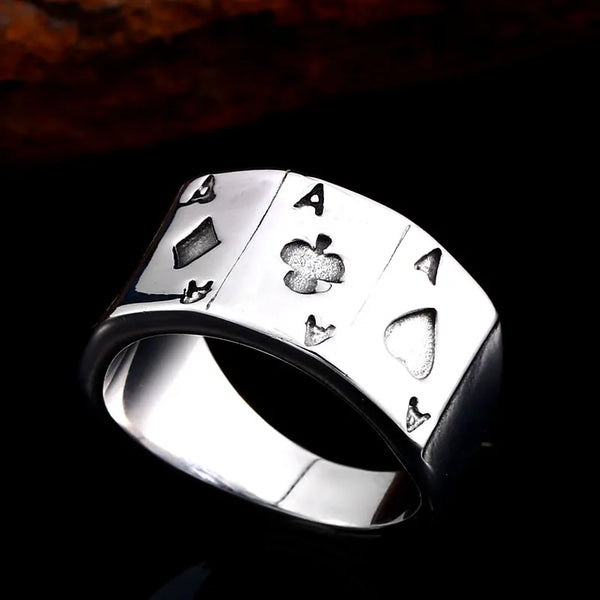 silver ring with four ace of spade cards