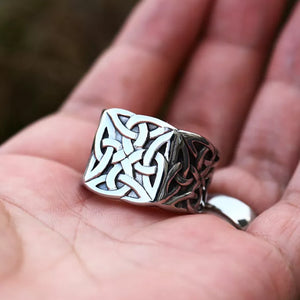 silver ring with celtic knot held in hand