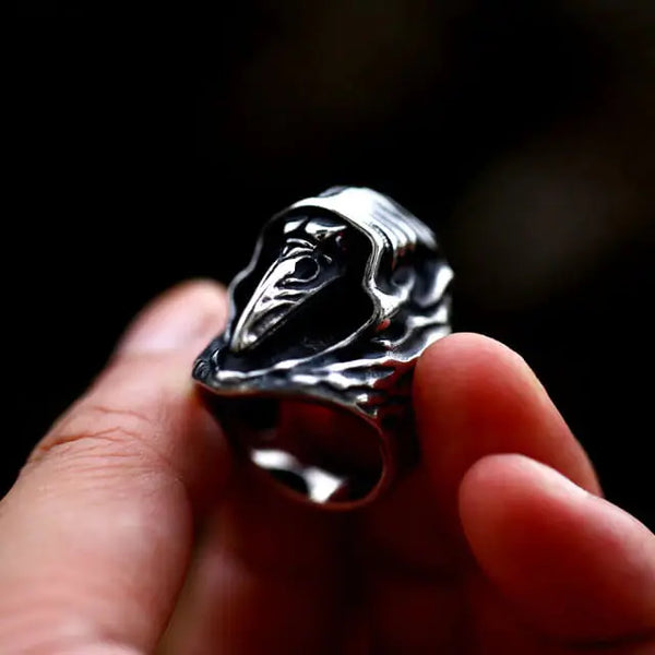 silver gothic ring of a plague doctor held in a hand