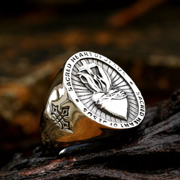 silver ring with heart cross and text stating sacred heart of Jesus
