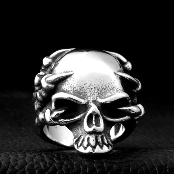 silver ring with claws grasping a skull