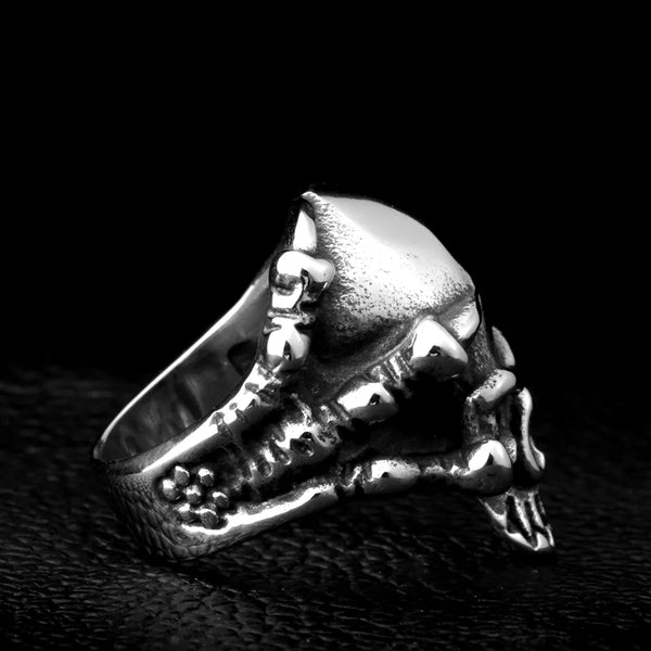 silver ring with claws grasping a skull