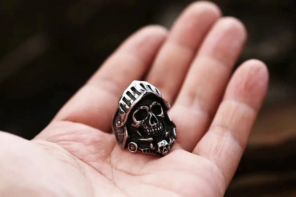 silver ring of a knight's skull and helmet armor held in a hand