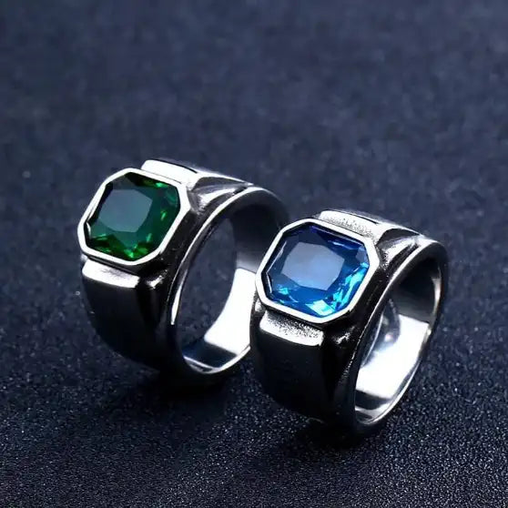 two silver signet rings with a blue and green gem